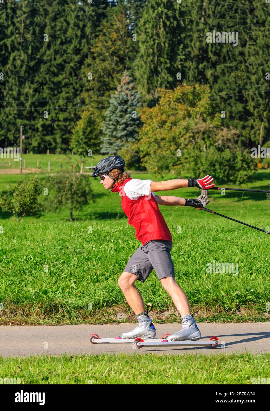 Junger und sportlicher Mann, der im Sommer eine anstrengende Ski-Roller-Sitzung macht Stockfoto