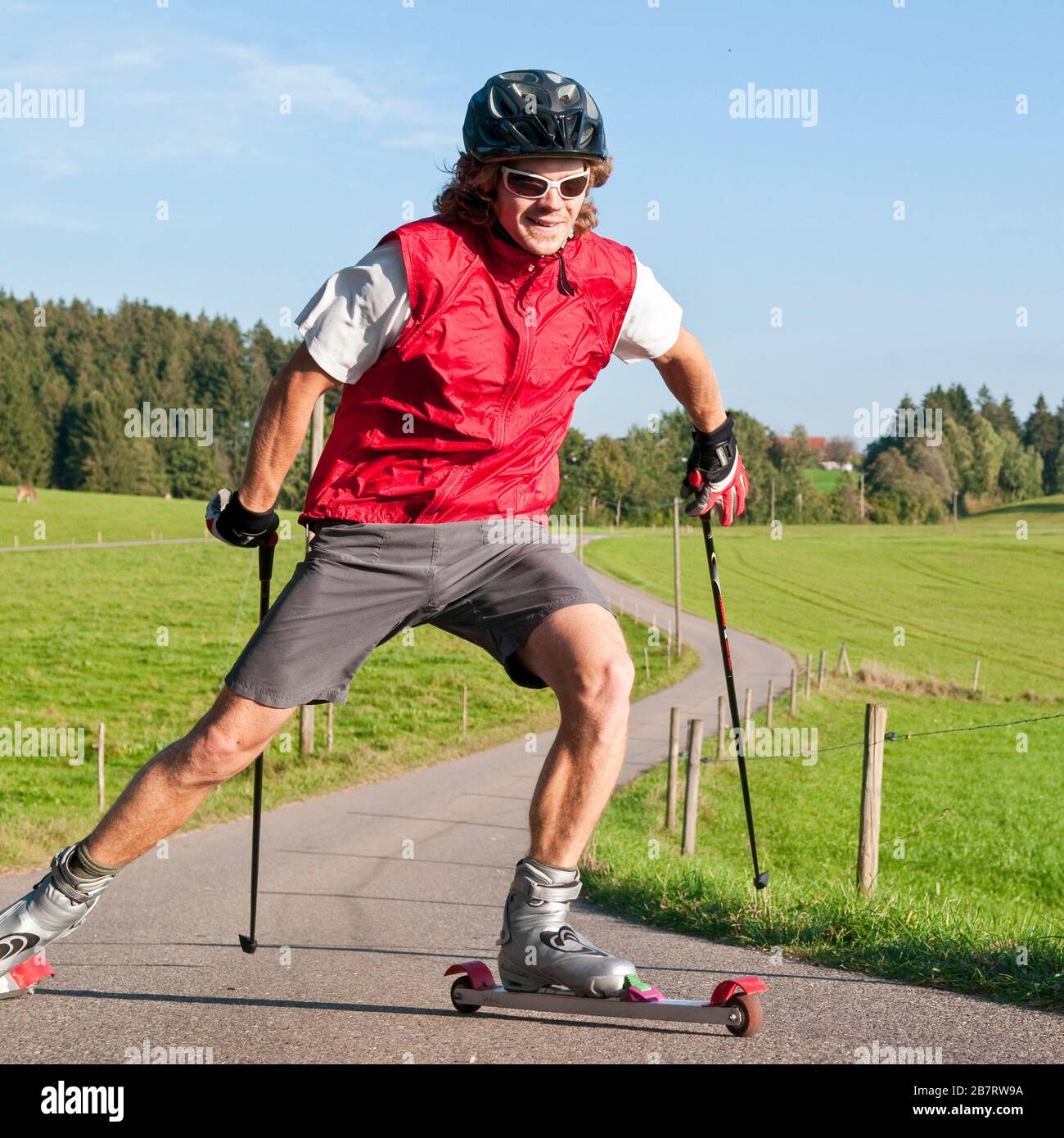 Junger und sportlicher Mann, der im Sommer eine anstrengende Ski-Roller-Sitzung macht Stockfoto