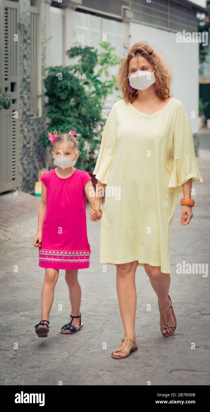 Frau und Tochter tragen eine Einwegmaske, um Virusinfektionen zu vermeiden. Schutz vor Coronavirus Stockfoto