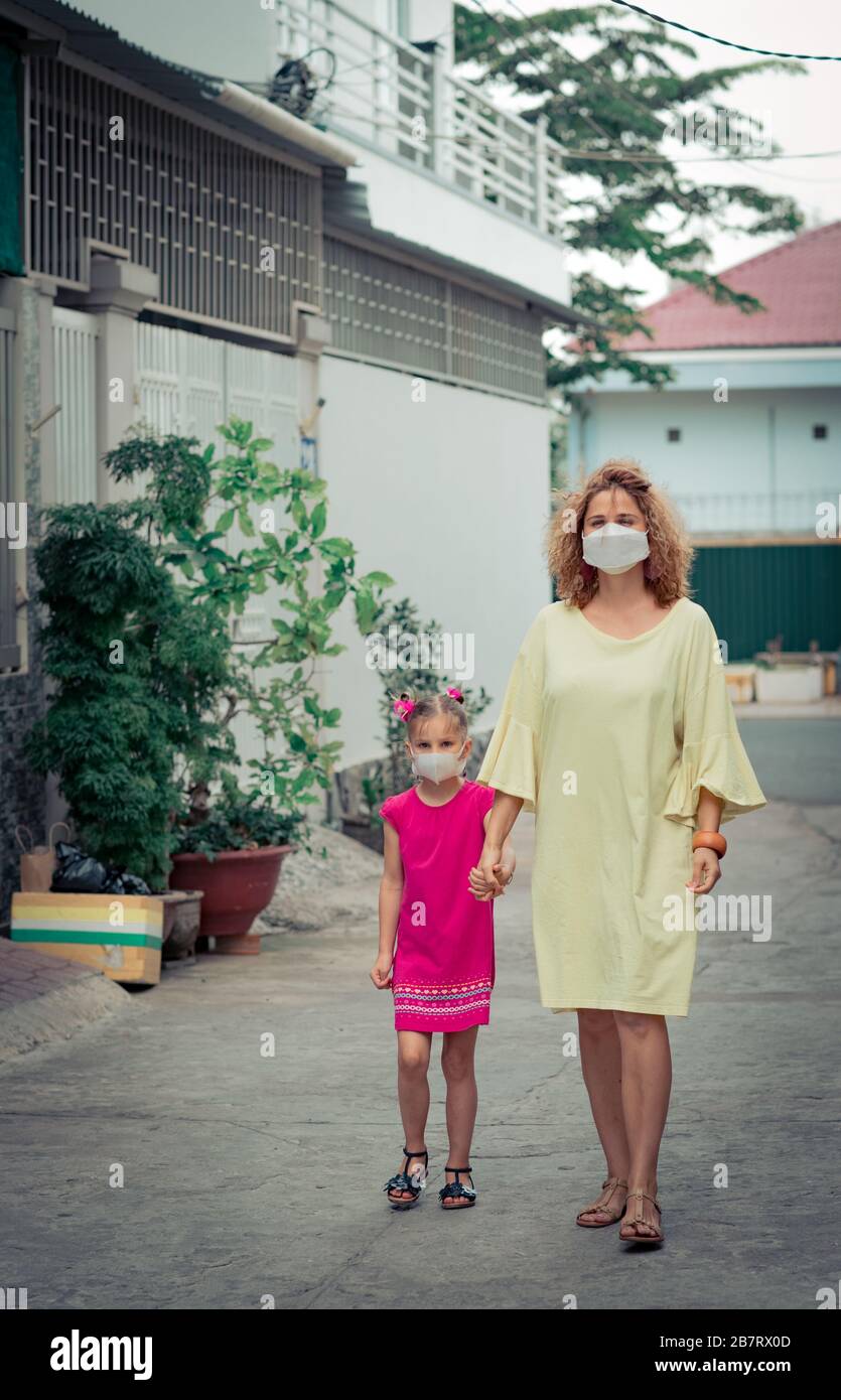Frau und Tochter tragen eine Einwegmaske, um Virusinfektionen zu vermeiden. Schutz vor Coronavirus Stockfoto