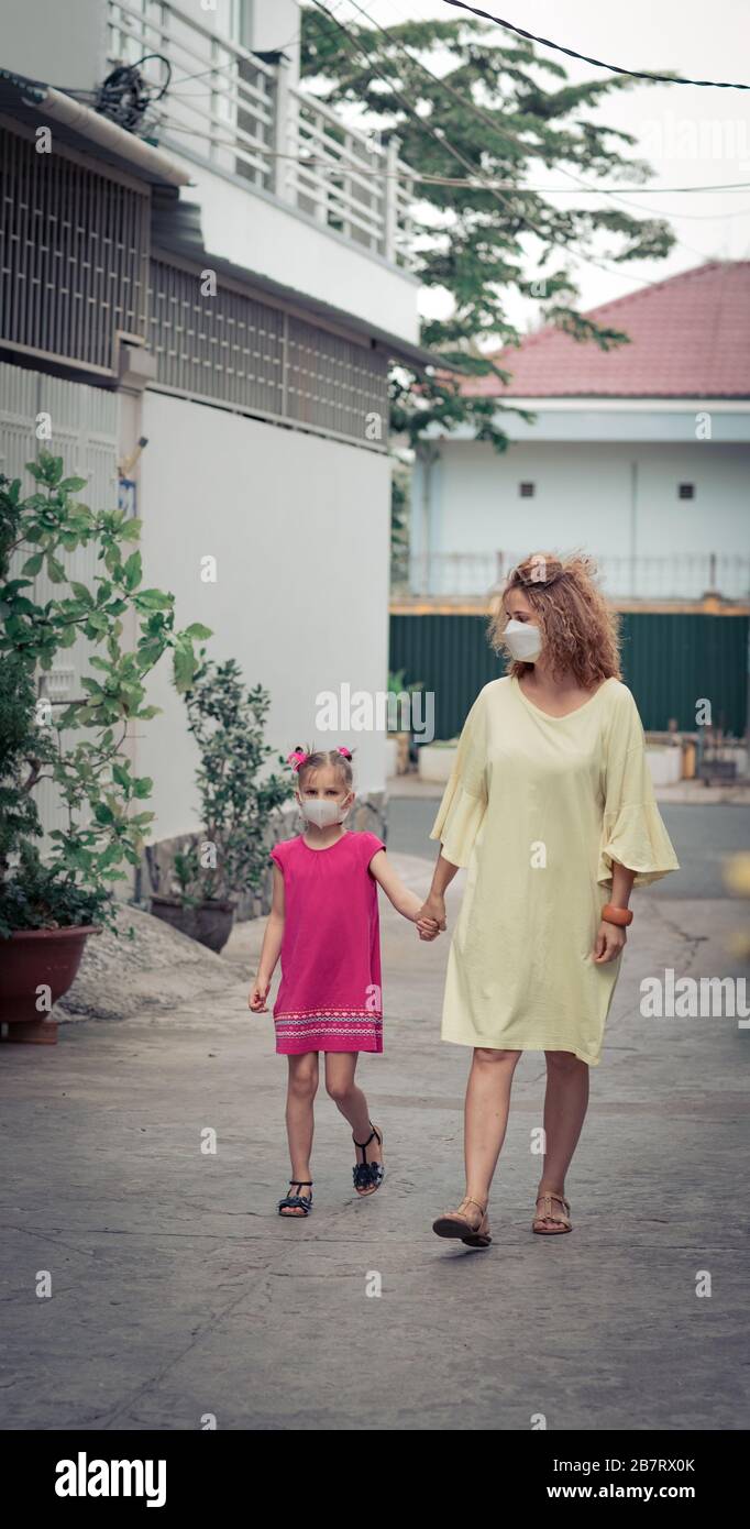 Frau und Tochter tragen eine Einwegmaske, um Virusinfektionen zu vermeiden. Schutz vor Coronavirus Stockfoto