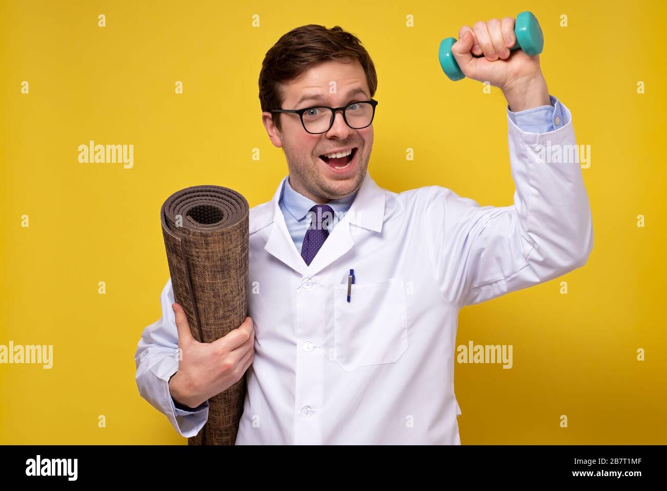 Ein reifer kaukasischer Mannarzt, der Hanteln hält und Ratschläge zu einem gesunden Lebensstil gibt. Sport- und Medizinkonzept. Stockfoto