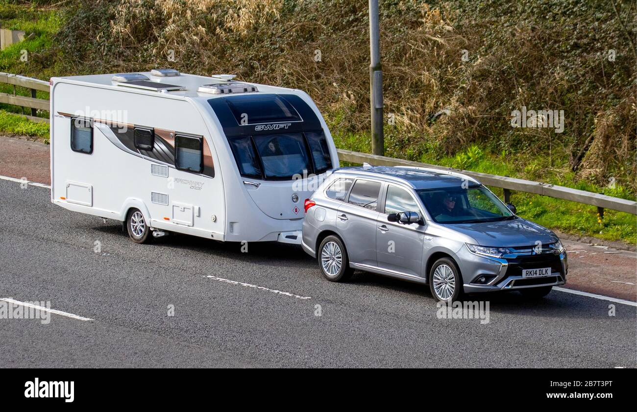 2018 Mitsubishi Outlander Juro PHEV CVT; UK Holiday Traffic, Transport, Moving Vehicles schleppen Swift Archway Sport Caravan, Fahrzeug, Straßen, Motoren, Fahren auf der Autobahn M6 Stockfoto