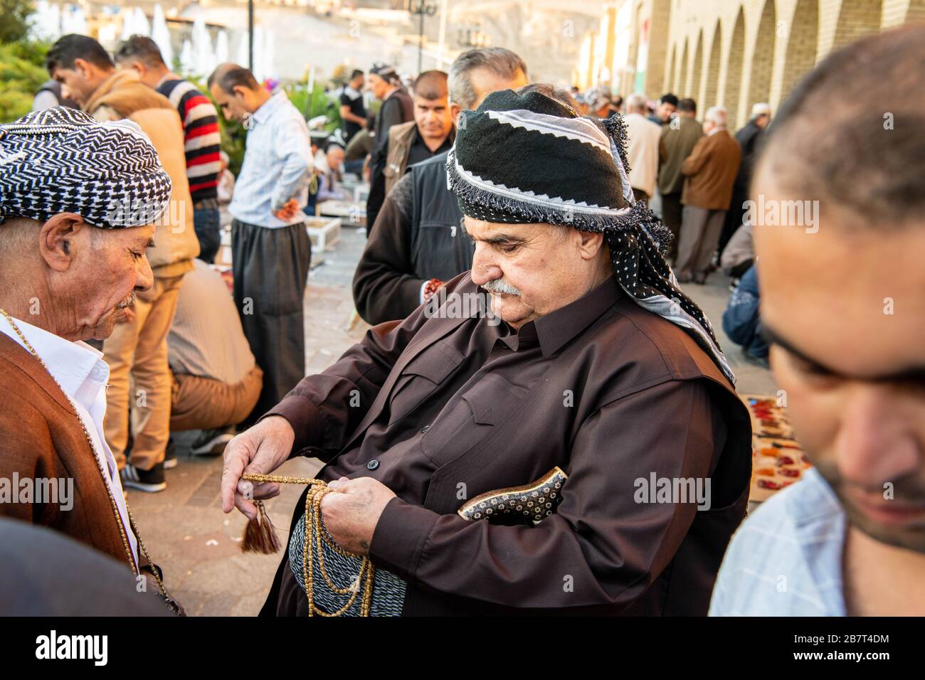 Der Irak, das irakische Kurdistan, Arbil, Erbil. Zwei Männer verhandeln über ein Gebetskapelett auf einer belebten Gasse neben dem Park Shar Stockfoto