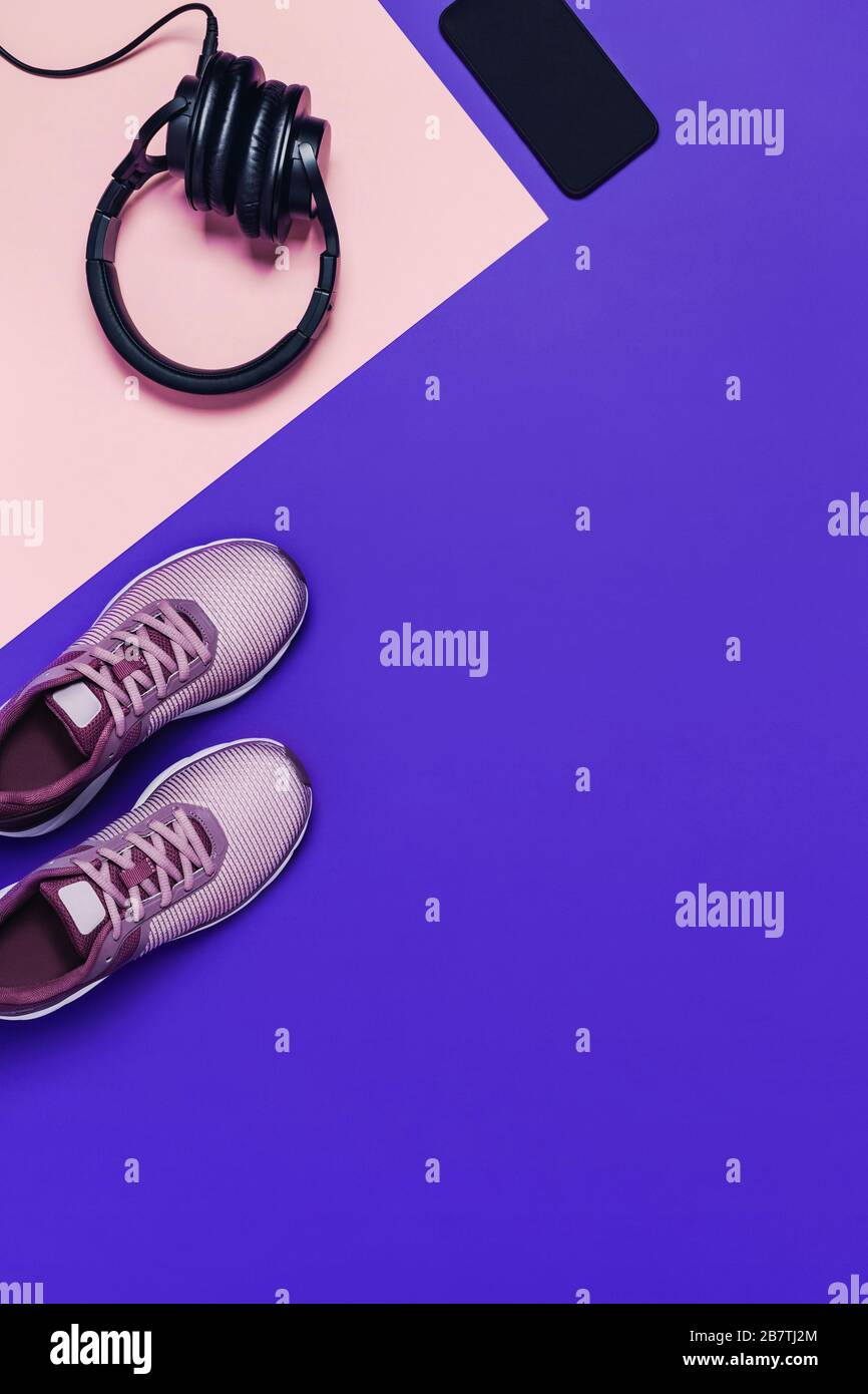 Sportausrüstung und Schuhe für das Frauentraining. Pink-blauer Hintergrund, vertikales Bild. Stockfoto