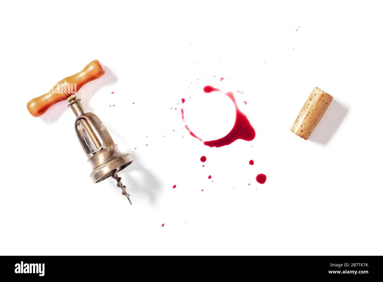 Vorlage für Weindesign. Ein Rotweinfleck mit einem Vintage-Korkenzieher und einem Kork, von oben auf weißem Hintergrund mit einem Platz für Text oder Logo geschossen Stockfoto