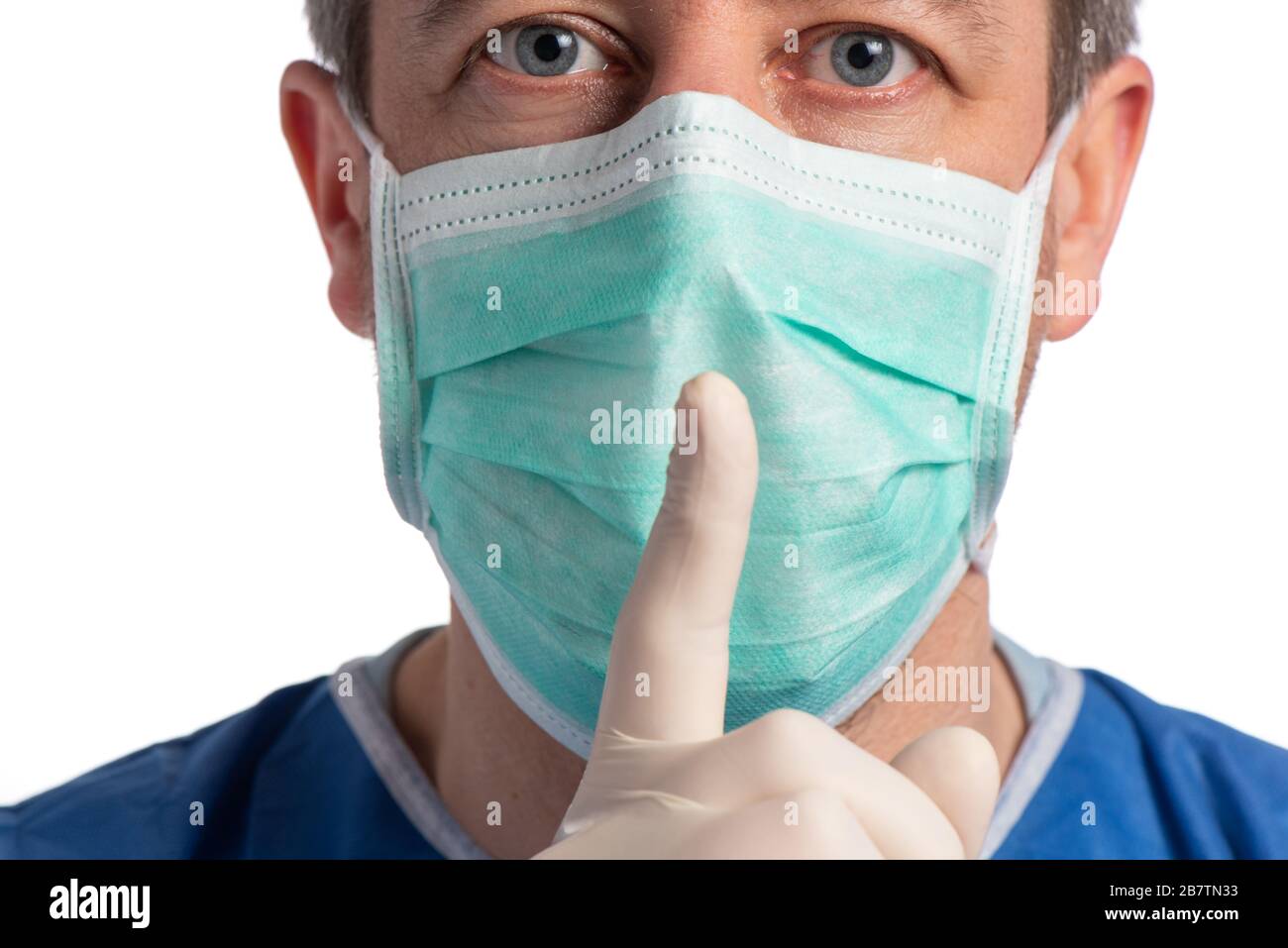 Kaukasischer Arzt trägt eine Schutzmaske, die auf weißem Hintergrund ein geschlossenes Schild bildet Stockfoto