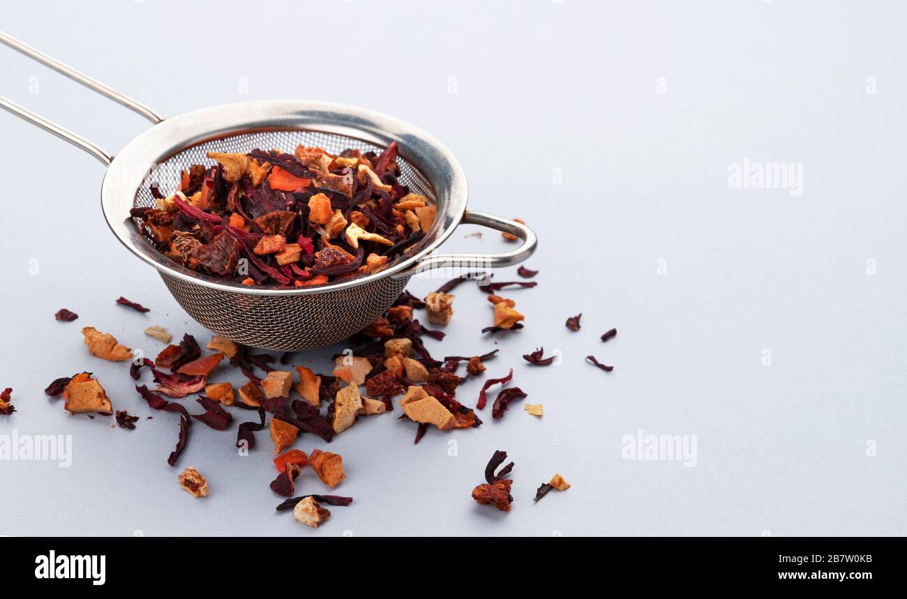 Teesieb mit Teeblättern und Früchten und Beeren Stockfoto