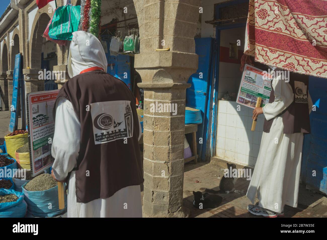 Männer aus der örtlichen Moschee forderten Almosen auf einem Marktplatz in Essaouira, Marokko Stockfoto