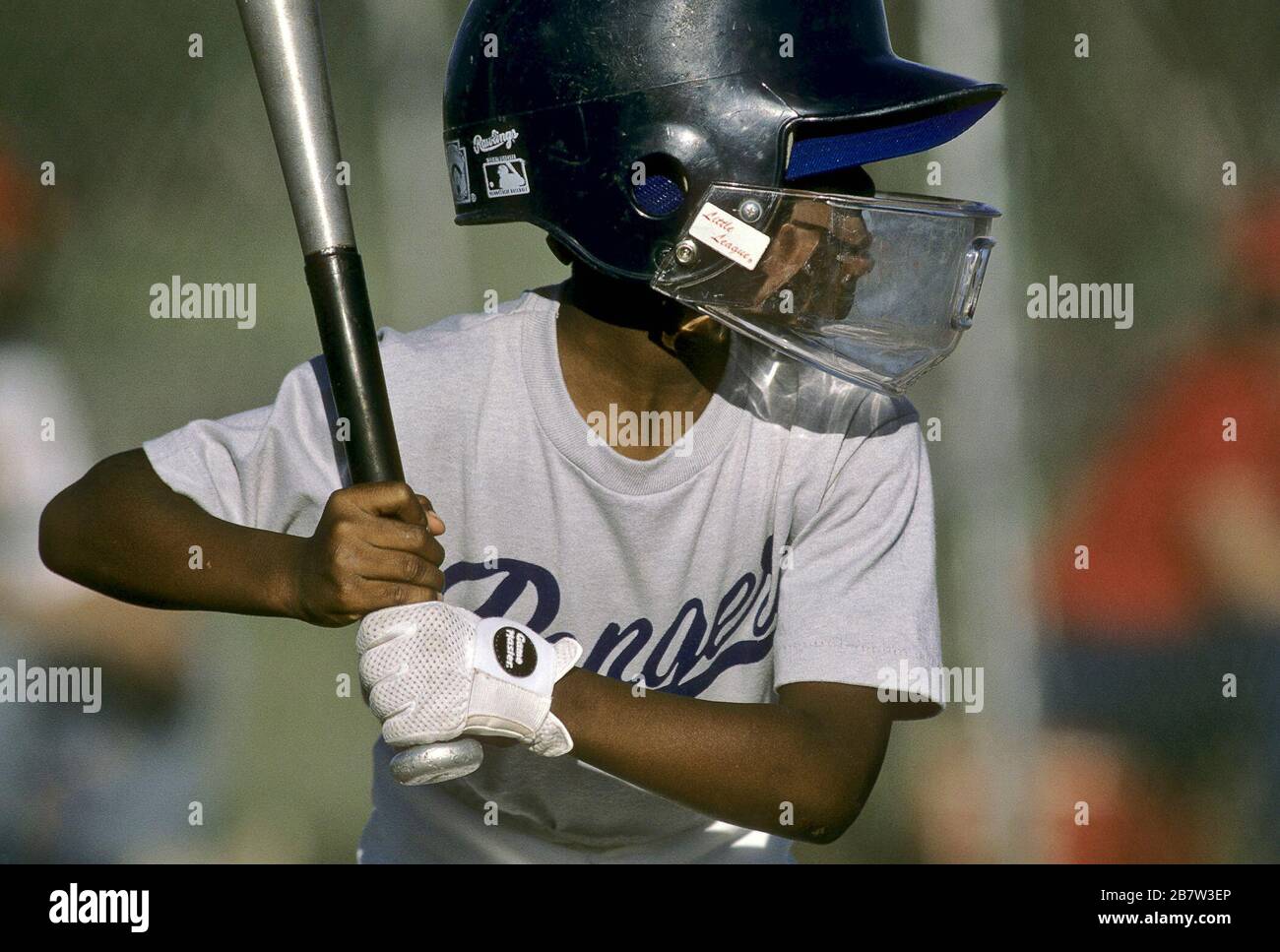 Austin, Texas USA: Schwarzer Junge an der Platte mit Aluminiumschläger und Schlaghelm mit Gesichtsschutz während des Baseballspiels der Jugendliga. ©Bob Daemmrich Stockfoto