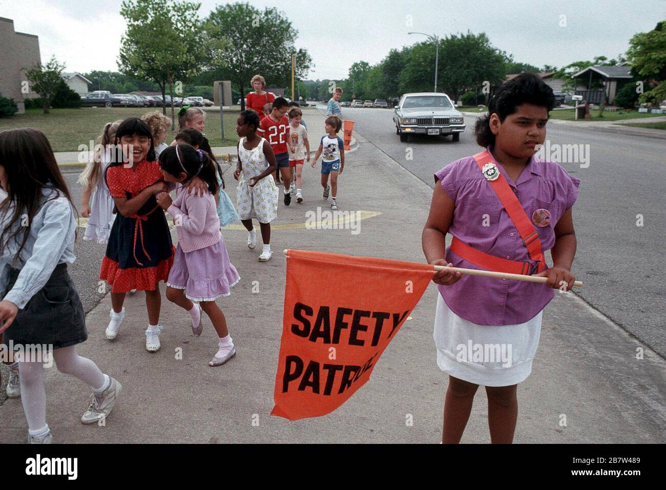 Austin Texas USA: Sicherheitssicherheitsmitglied der Grundschule hilft Klassenkameraden, nach der Schule sicher die Straßen zu überqueren. ©Bob Daemmrich Stockfoto