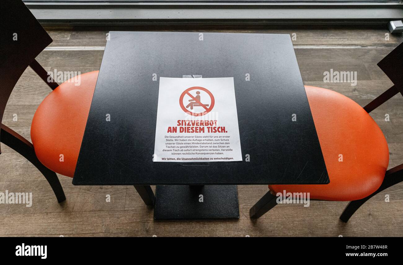 18. März 2020, Hamburg: Ein Schild mit der Aufschrift "an diesem Tisch sitzt nicht" zeigt an, dass dieser Tisch nicht belegt sein darf, um einen Mindestabstand zwischen Gästen in einem Restaurant einzuhalten. Der Mindestabstand soll eine Infektion mit dem Coronavirus verhindern. Foto: Markus Scholz / dpa Stockfoto