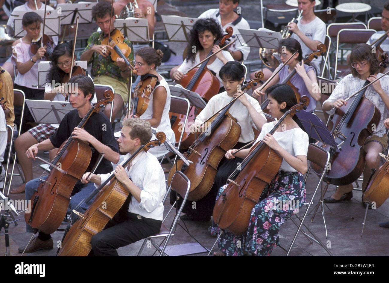 Girona, Spanien, 1992: Mitglieder der Streicherabteilung des World Youth Orchestra Proben im Freien, bevor sie ein Konzert präsentieren. ©Bob Daemmrich Stockfoto