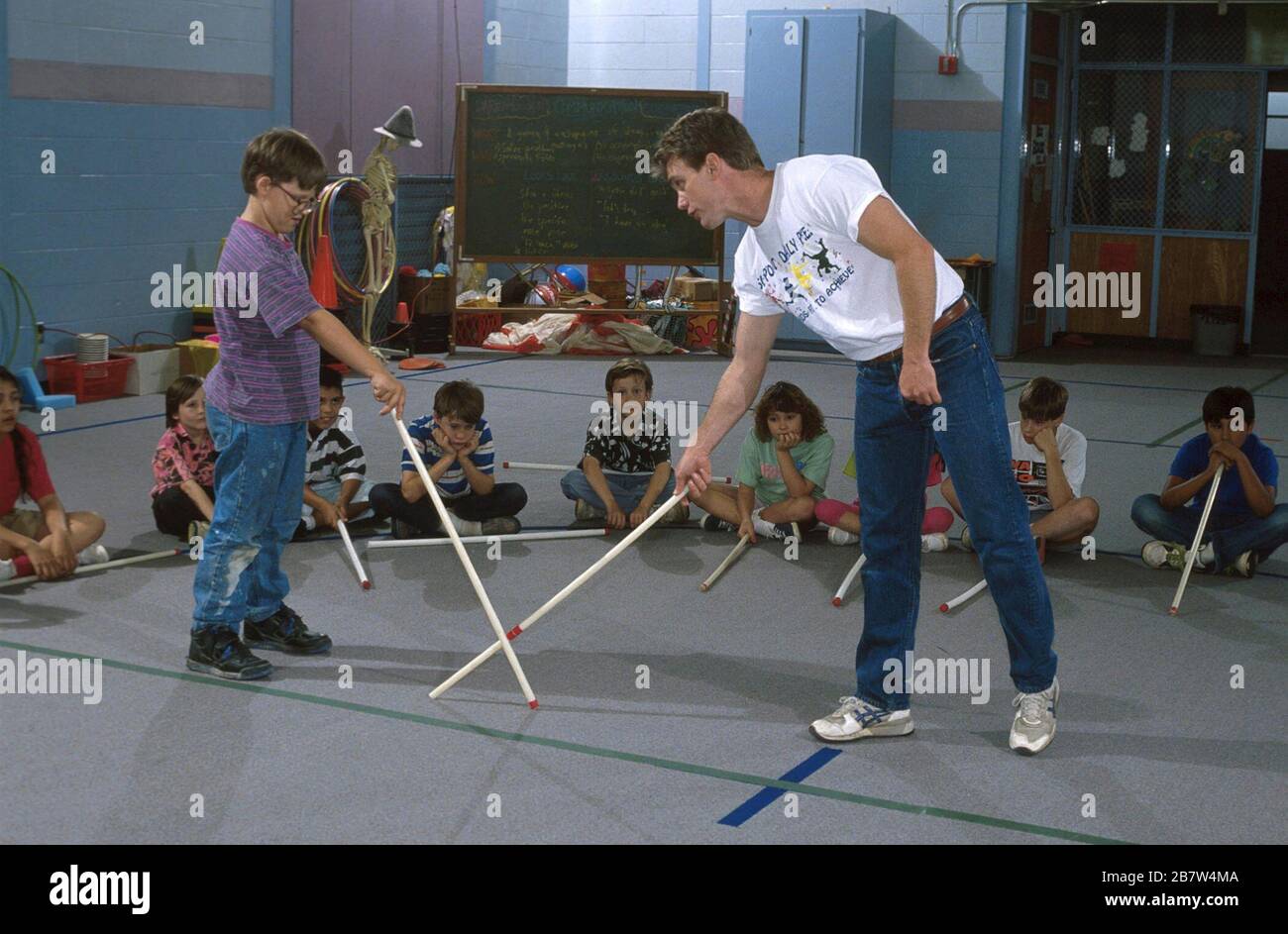 Austin Texas USA: Männlicher Sportlehrer führt die Klasse in das Spiel „Toe Fechten“ an der Walnut Creek Elementary School ein. ©Bob Daemmrich Stockfoto