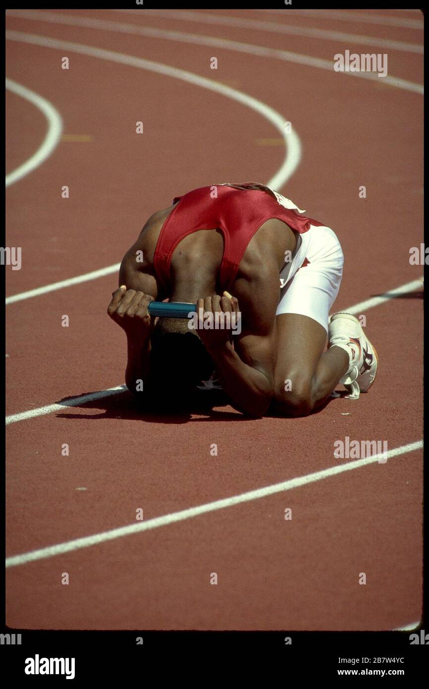 Seoul Korea, 1988: Der erschöpfte Staffelläufer fällt auf die Knie, nachdem er während des Streckenwettbewerbs bei den Olympischen Sommerspielen die Ziellinie des Rennens überquert hat. ©Bob Daemmrich Stockfoto