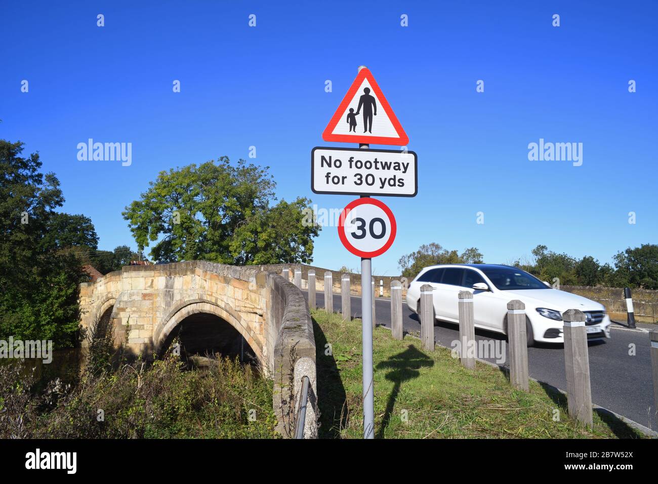 LKW, der keinen Fußraum für Fußgänger in vorausfahrender Straße passiert, Warnschild auf der Brücke, die den Fluss derwent in sutton auf derwent united überquert Stockfoto