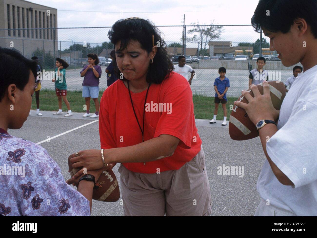 Austin Texas USA: Die Lehrerin zeigt der Schülerin, wie sie Fußball während der Freiluftgymnasium-Klasse in der Mittelschule hält. ©Bob Daemmrich/ Stockfoto