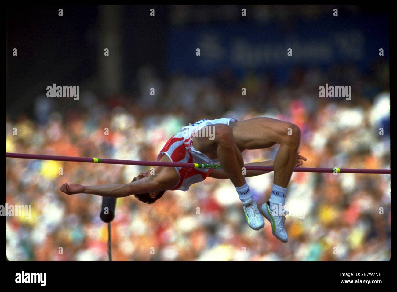 Barcelona Spanien, 1992: Konkurrent strapagt sich, um die Latte beim Hochsprung der Männer während des Leichtathletik-Finals bei den Olympischen Sommerspielen zu räumen. ©Bob Daemmrich Stockfoto