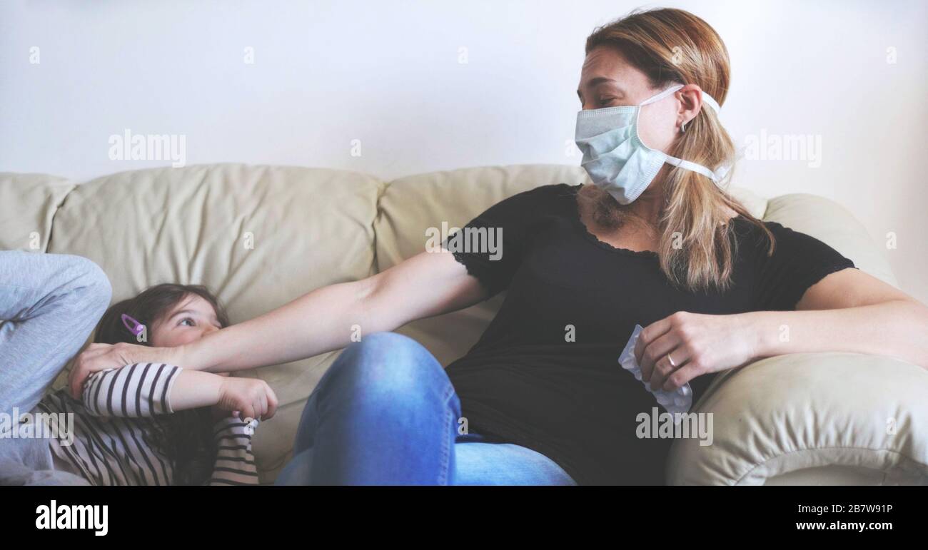 Mutter mit viraler Infektion des Coronavirus Kovid 19 halten ihr Baby als Vorsichtsmaßnahme gegen Ansteckung auf Distanz Stockfoto