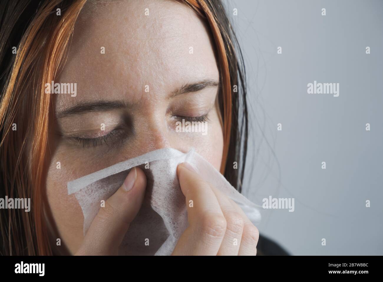Niesen, Husten oder Blasen der Nase in einem einzigen Papiertowl. Das Konzept, Kälte, Viren oder Infektionen zu fangen und nicht zu verbreiten Stockfoto