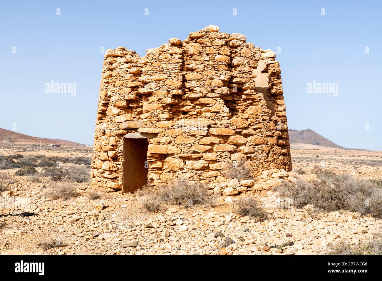 Die Ruinen einer alten Windmühle aus Stein, die früher zur Grundwasseraufhebung für die Bewässerung in der Nähe von Tuineje im Zentrum der Kanareninsel Fuerteventura diente Stockfoto