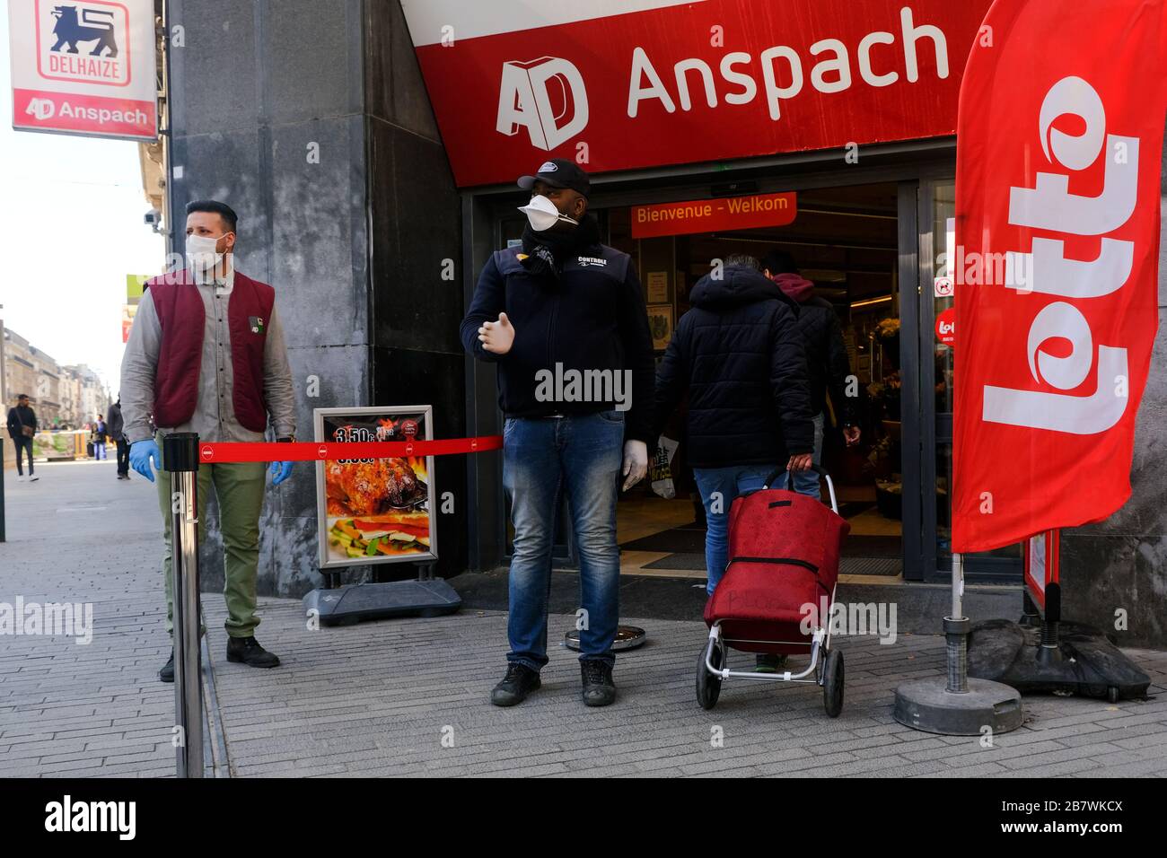 Brüssel, Belgien. März 2020. Ein Wachmann kontrolliert den Eingang eines Supermarktes, bevor die belgische Regierung einen Coronavirus-Lockdown verhängt. Credit: ALEXANDROS MICHAILIDIS/Alamy Live News Stockfoto