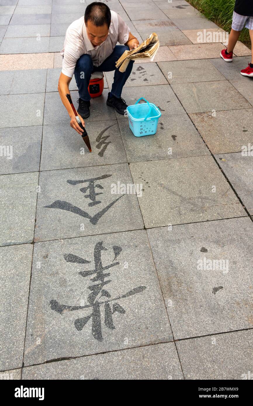 Mann, der dishu oder chinesische Boden Kalligraphie praktiziert, Xian, China Stockfoto