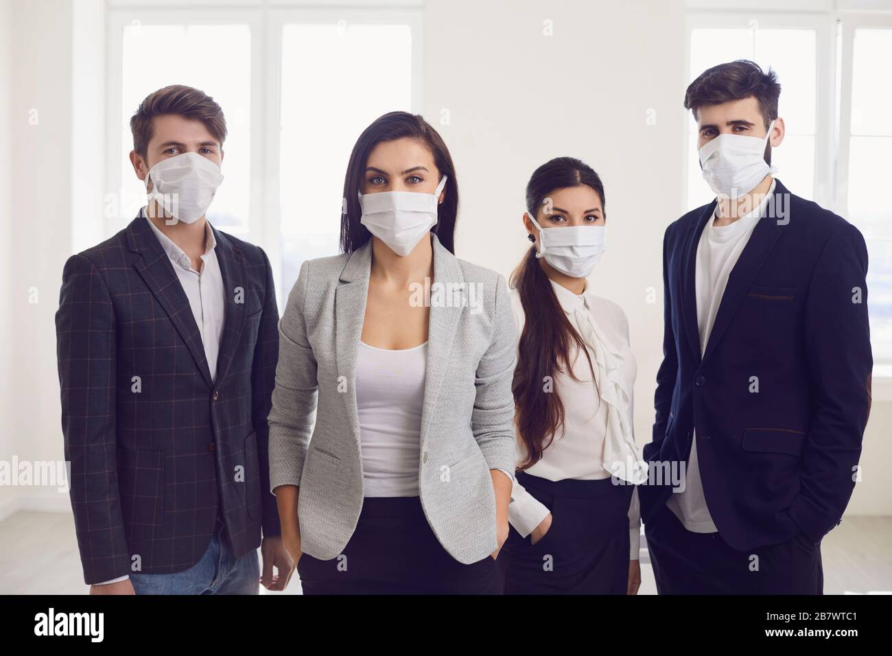 Infektionsgefahr der Virus-Coronavirus-Infektion. Gruppenleute Geschäftsleute in medizinischer Maske im Büro. Stockfoto