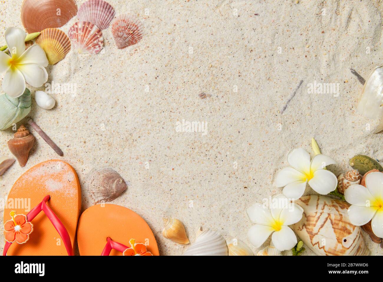 Oraneg Sandale mit Schalen und Plumeria Blumen auf Sandgrund, Platz für Texteingabe und Reise im Sommerzeitkonzept Stockfoto