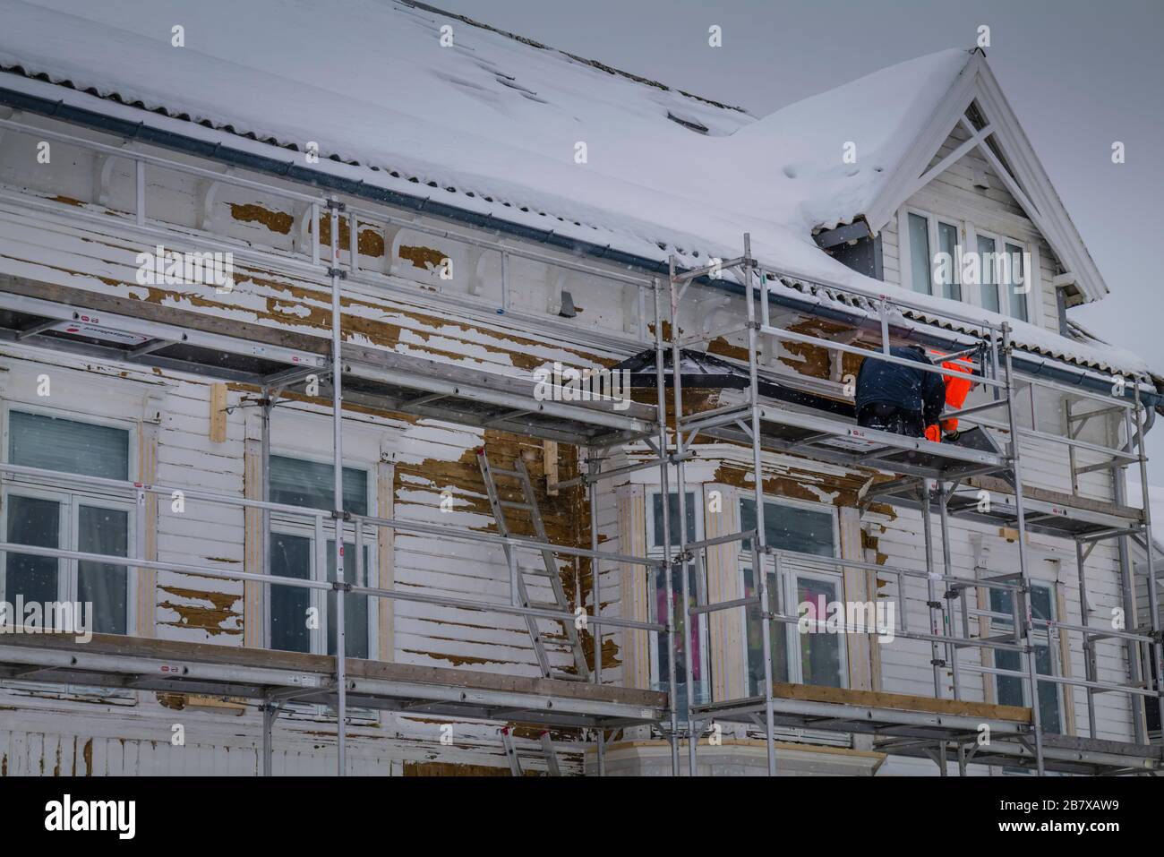 Die Arbeit an einem Haus in Tromso geht trotz des Schnees, Norwegen, weiter. Stockfoto