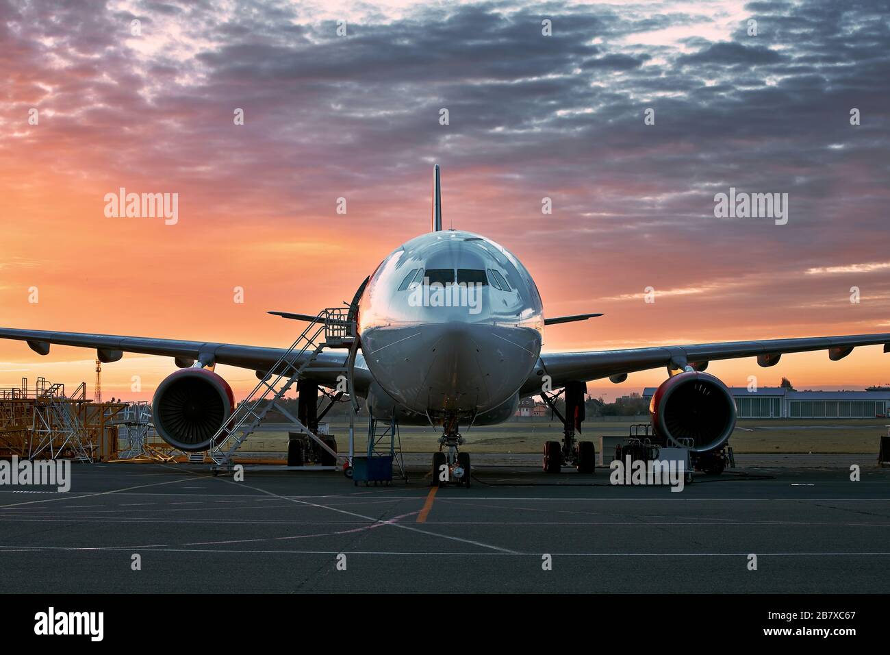Vorderansicht des Flugzeugs während der Wartung gegen modrigen Sonnenaufgang. Stockfoto