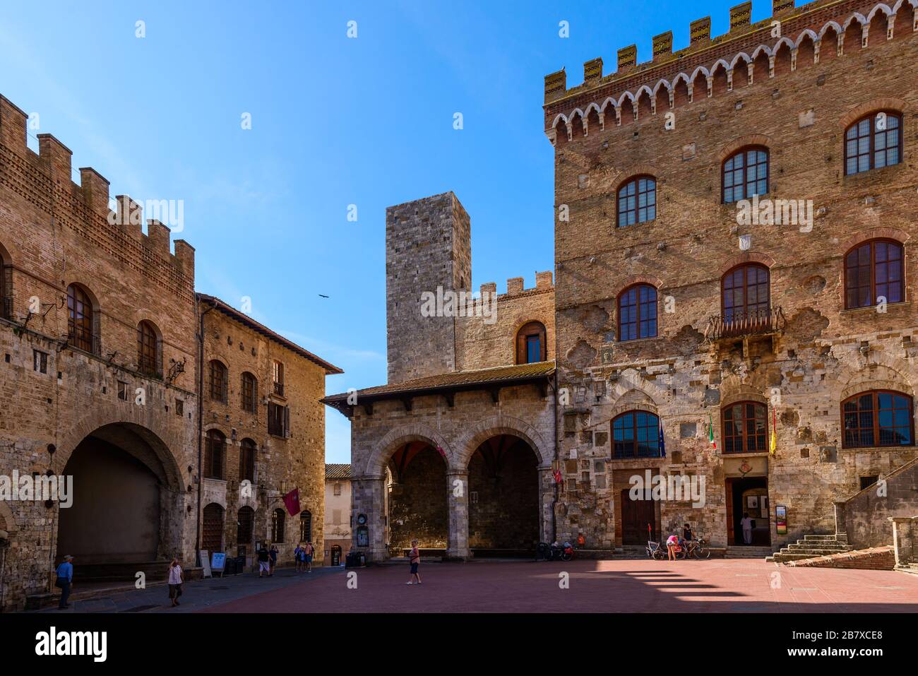 San Gimignano, Toskana: Der Palazzo Comunale, auch bekannt als Palazzo del Popolo, mit dem Palazzo Vecchio del Podestà links auf der Piazza del Duomo Stockfoto