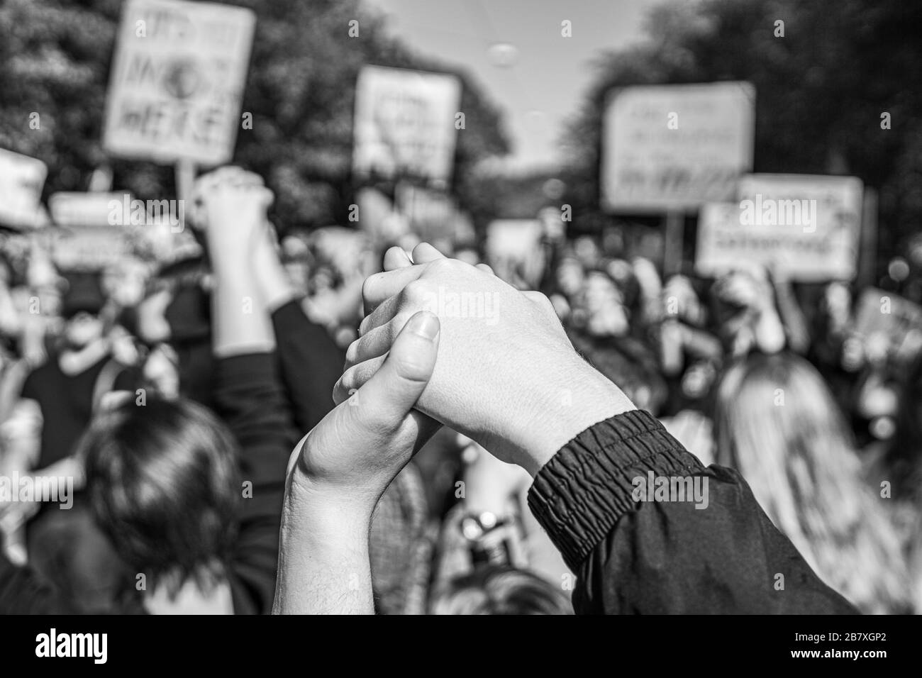 Fotografieren Sie in Schwarzweiß von zwei Personen, die sich freitags zu einem zukünftigen Protest gegen den Klimawandel zusammenschließen und damit die Kraft symbolisieren Stockfoto