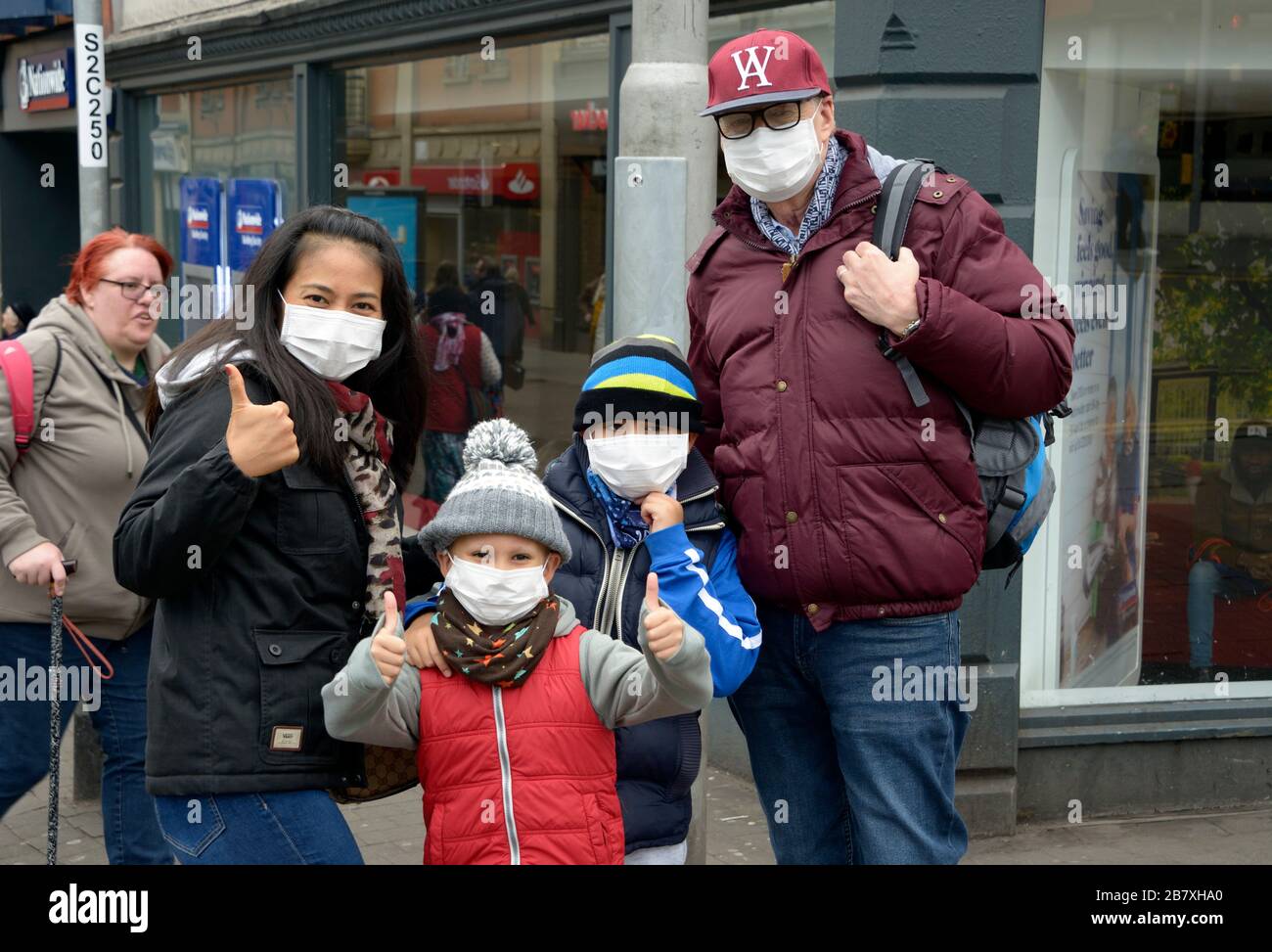 Britische Familie, alle in Masken, um Coronavirus zu verhindern Stockfoto