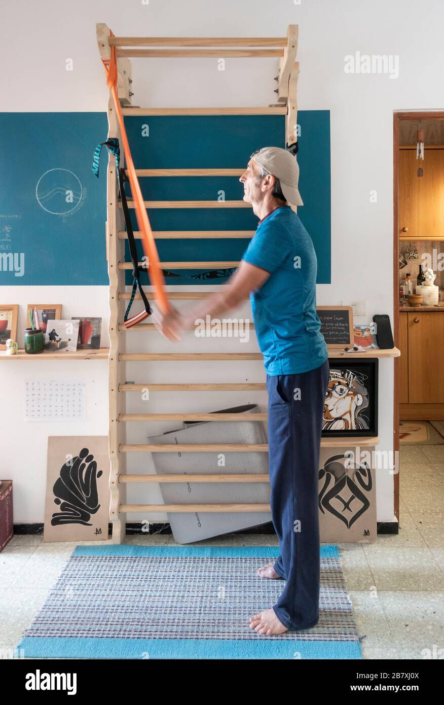 61 Jahre alter Mann trainieren zu Hause auf hausgemachte Wand bars in kleine Wohnung. Stockfoto