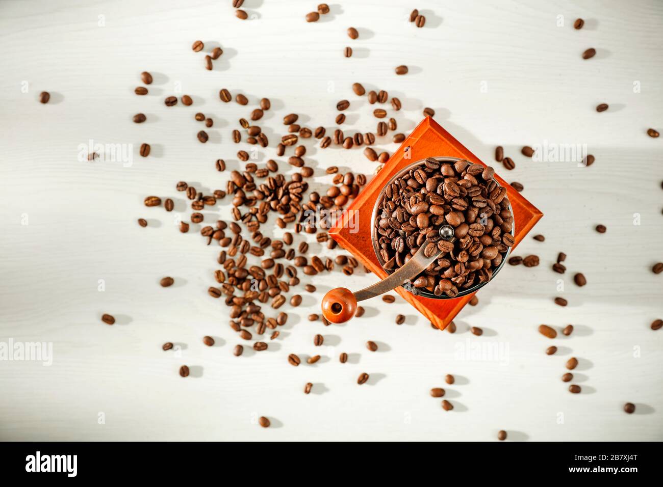 Braune Kaffeebohnen und Kaffeemühle von oben gesehen. Kaffee mit weißem Hintergrund. Kopierbereich. Platz für Werbemittel. Stockfoto