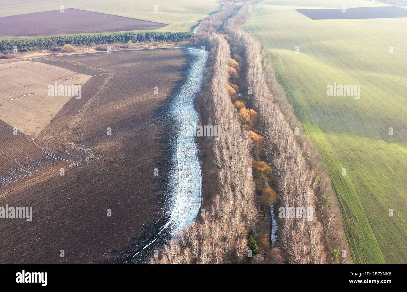 Landschaft des ukrainischen Landes - ein Feld, eine Vielzahl von Bäumen, Schnee auf schwarzem Land. Schöne Aussicht von der Drohne. Schöne Landschaft. Sitzung von drei Meere Stockfoto
