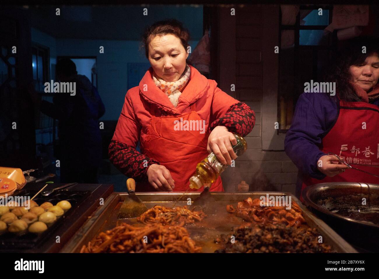 Wuhan, China in der Provinz Hubei, wurde 2013 gedreht und zeigt Stallhalter, die gekochte Speisen zubereiten und servieren. Stockfoto