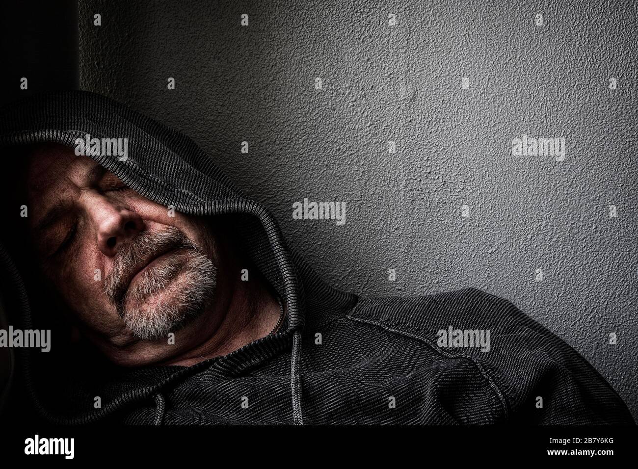 Ein Mann mittleren Alters, der sich in einem ermüdeten Zustand befindet und an Depressionen leidet. Stockfoto