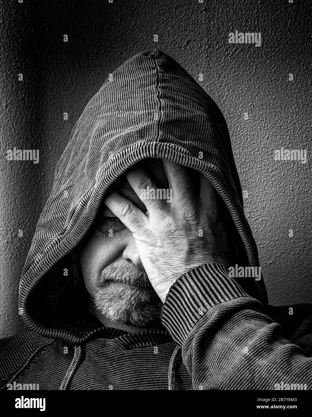 Ein Mann mittleren Alters fühlt sich in seiner Depression hilflos an. Stockfoto