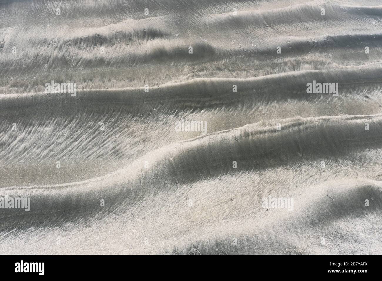 dh SANDMUSTER sandig gewellte Struktur an Land Stockfoto