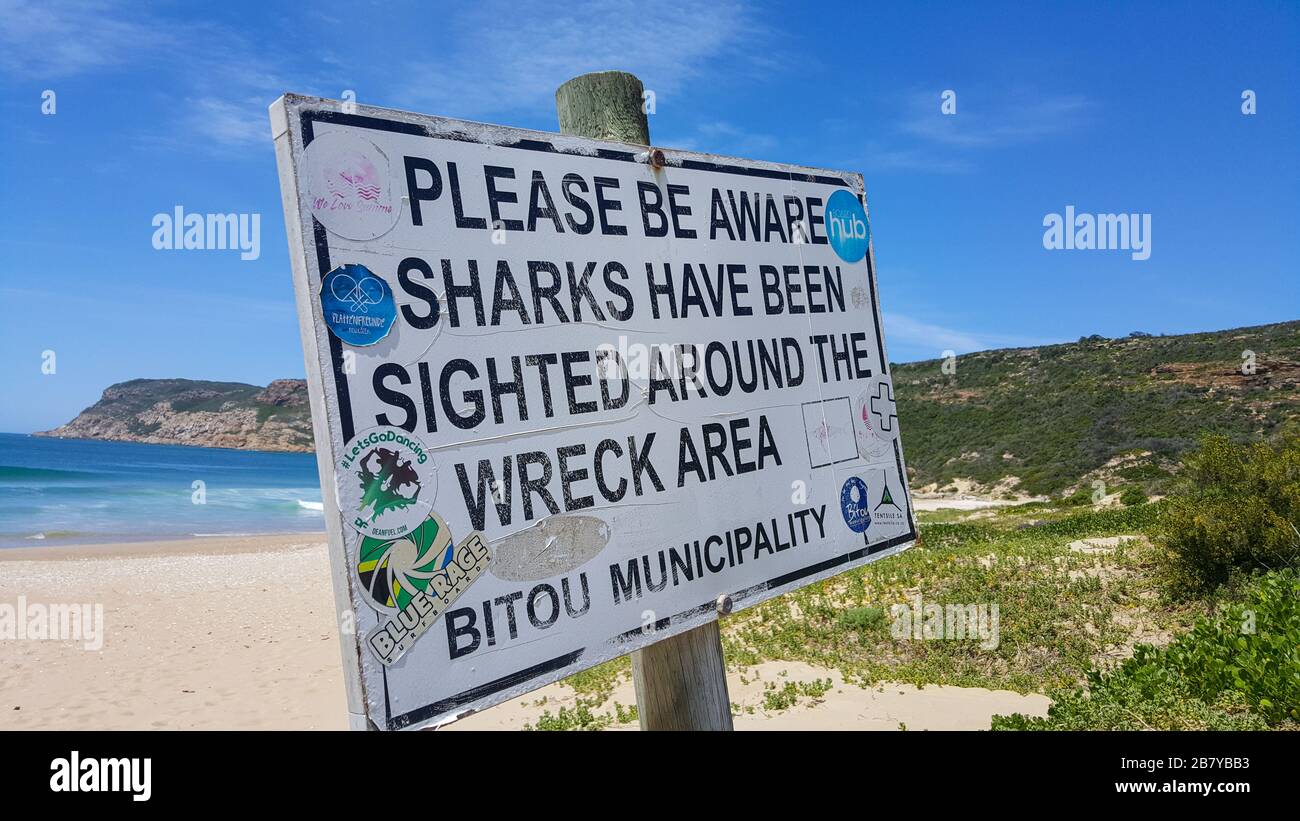 Ein Schild mit Hai-Warnzeichen am Strand der Plettenberg Bay in Südafrika Stockfoto