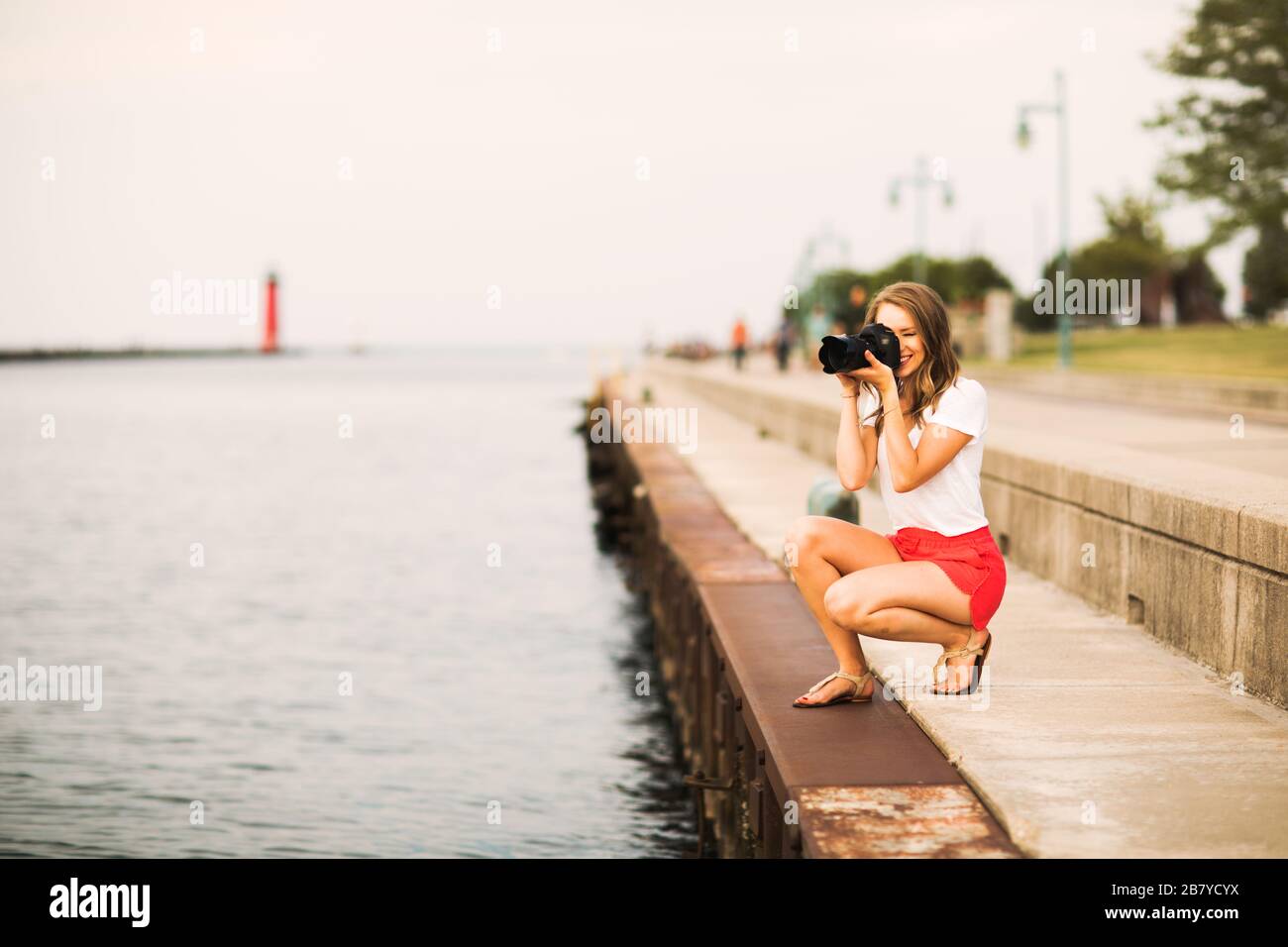 Junge Fotografin - Fotos von Sonnenuntergang am See Stockfoto