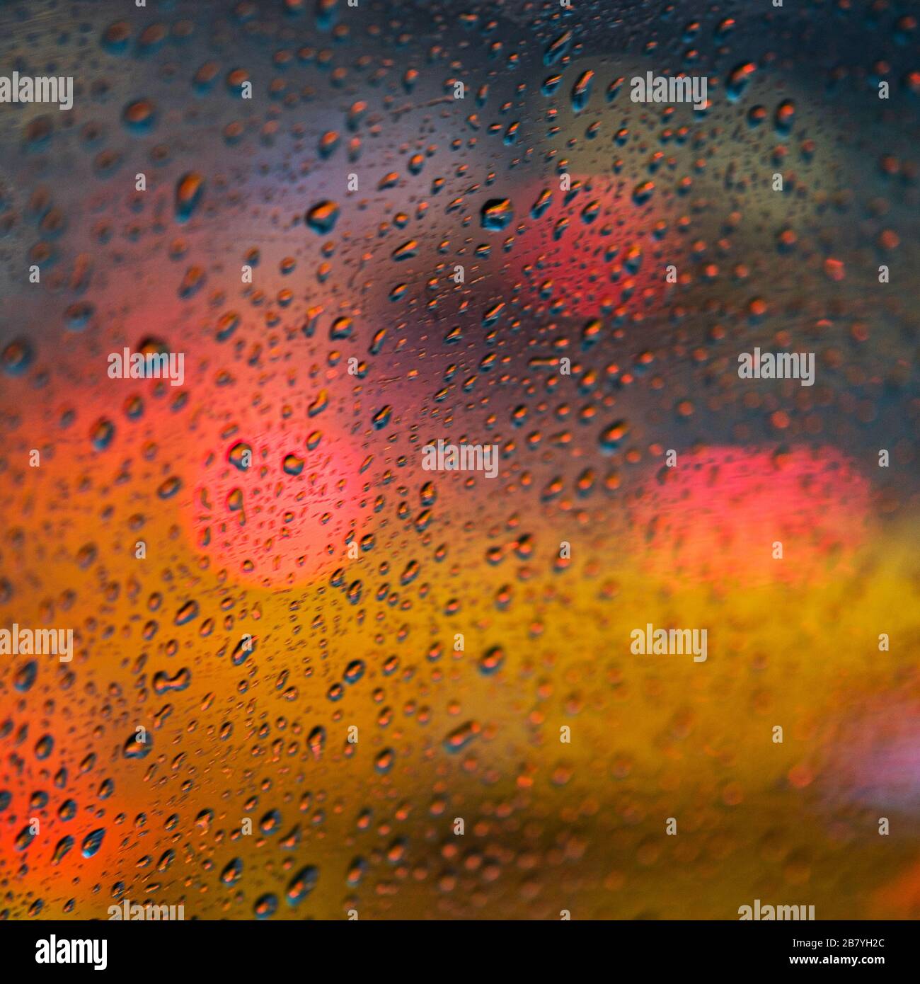 Defokusstes Licht hinter nassem Fenster Stockfoto