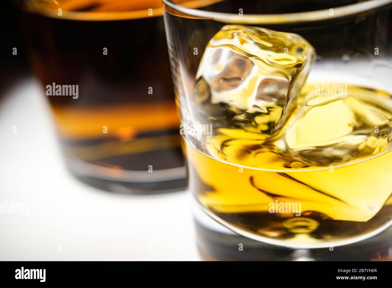 Glas Whiskey mit Eiswürfeln per Flasche Stockfoto