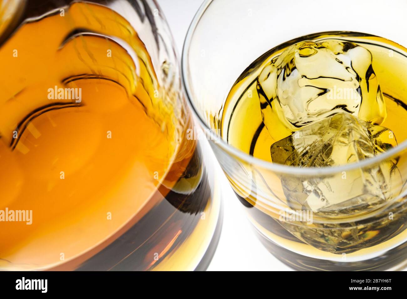 Glas Whiskey mit Eiswürfeln per Flasche Stockfoto