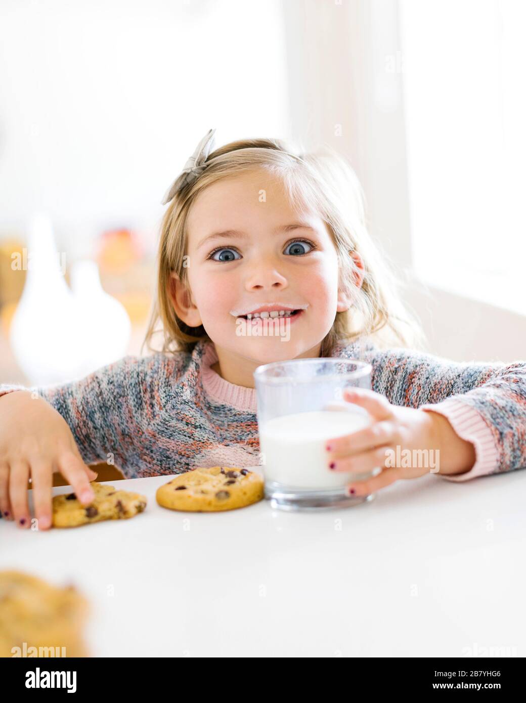 Mädchen, Essen, Milch und Kekse Stockfoto