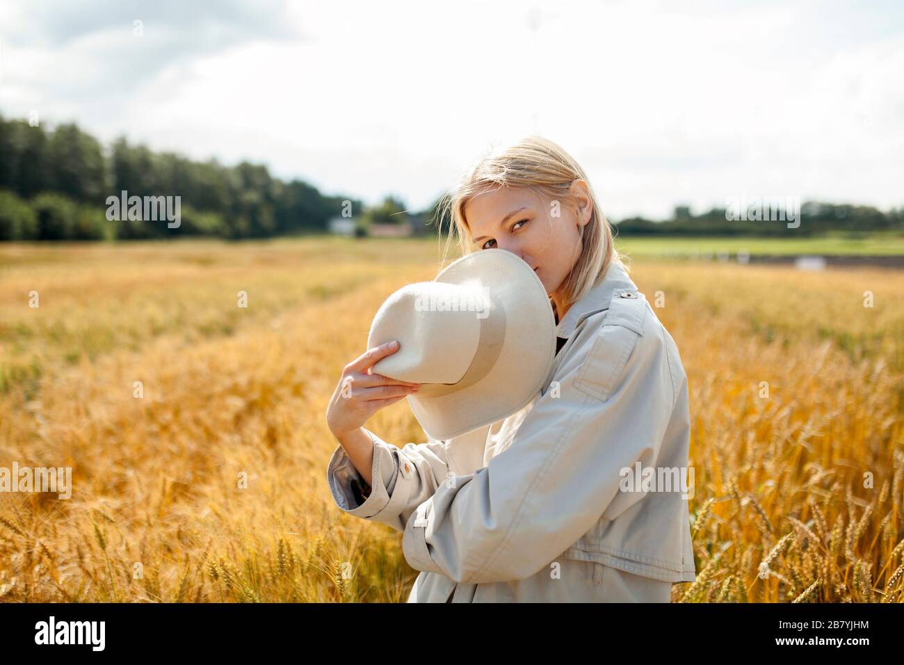 Junge Frau mit Fedora im Weizenfeld Stockfoto