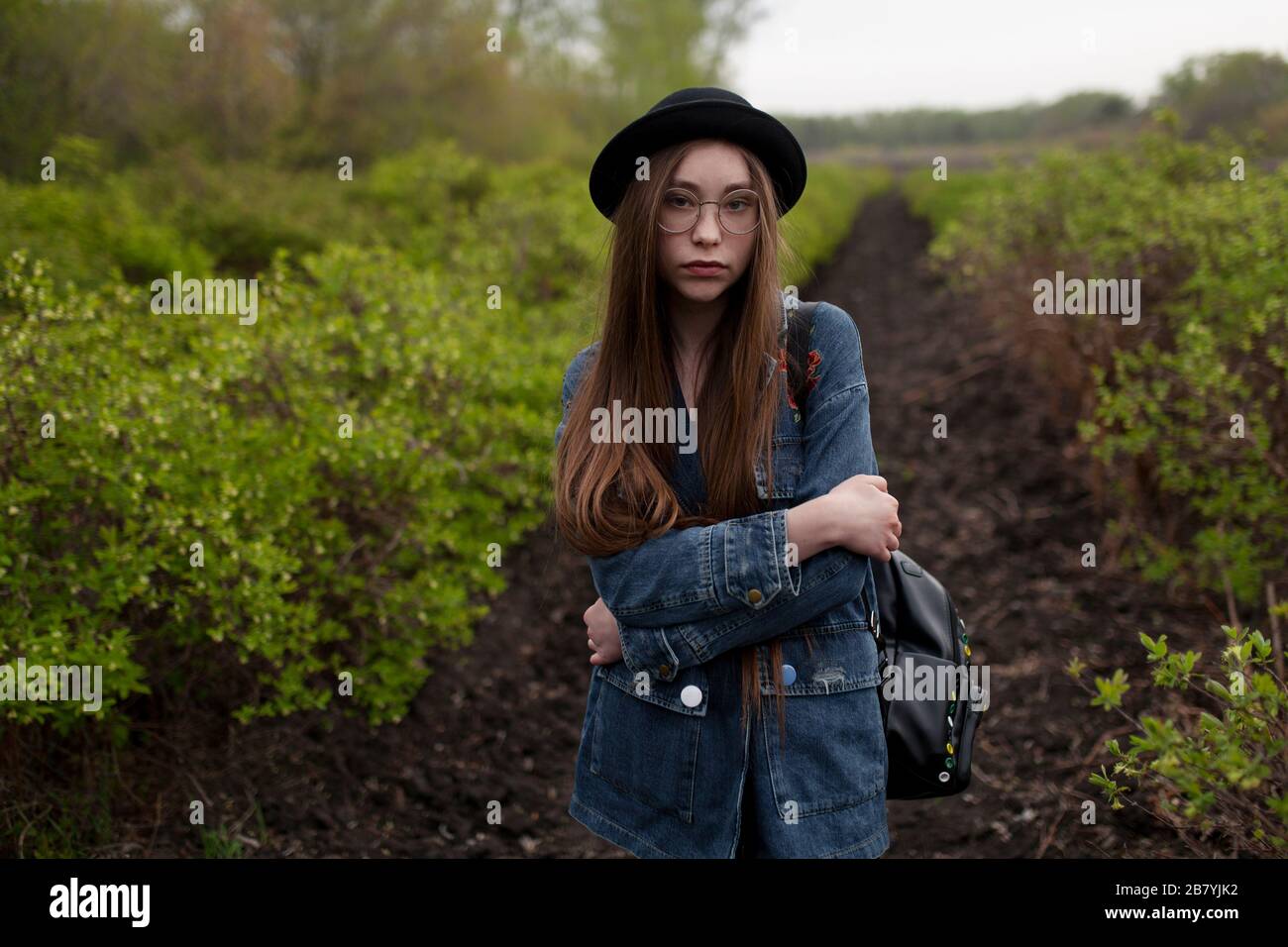Junge Frau mit Jeansjacke im Feld stehend Stockfoto