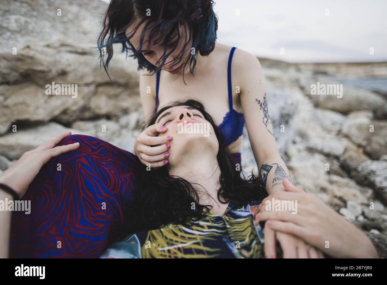 Junger Mann, der auf dem Schoß der Frau am Strand liegt Stockfoto